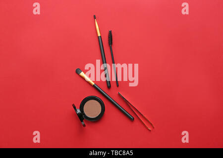 Set of tools for eyebrows correction and eyeshadows on color background Stock Photo