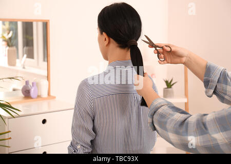Woman cutting hair of young girl. Concept of donation Stock Photo