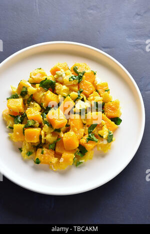 Stir-fried pumpkin with eggs on plate over blue stone background. Pumpkin and egg stir fry in thai style. Stock Photo