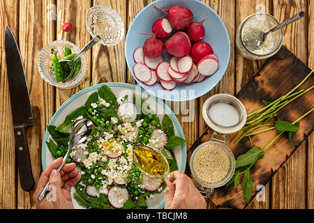 Woman prepares healthy food according to the recipe on a wooden table in the home kitchen Stock Photo