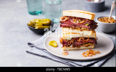 Roast beef sandwich on a plate with pickles. Copy space. Stock Photo