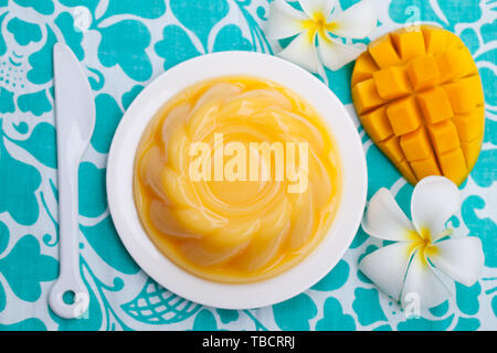 Mango pudding, jelly, dessert on white plate with fresh fruit. Blue background. Top view. Stock Photo