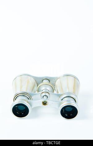 Used binoculars with perl grips on white background, elegance tool for to watch entertainment closely Stock Photo