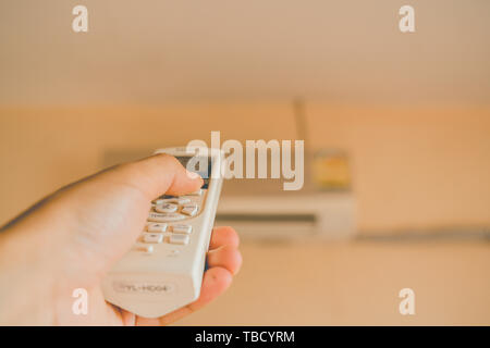 Hand holding remote control air conditioner Stock Photo