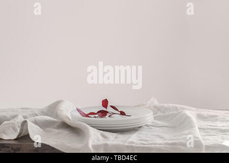 Stack of clean plates on table against light background Stock Photo