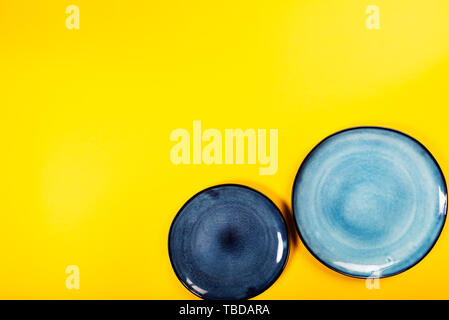 Empty Blue Plates on Bright Yellow Background, Top View, Copy Space Stock Photo