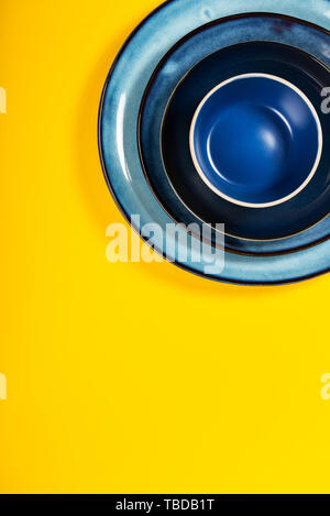 Empty Blue Plates on Bright Yellow Background, Top View, Copy Space Stock Photo