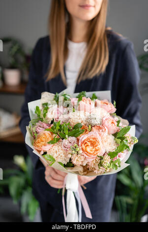 Small Beautiful bouquet of mixed flowers in woman hand. Floral shop concept . Beautiful fresh cut bouquet. Flowers delivery Stock Photo