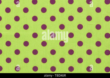 Close up of yellow background in a black polka dots, metal plate in the hole. Stock Photo