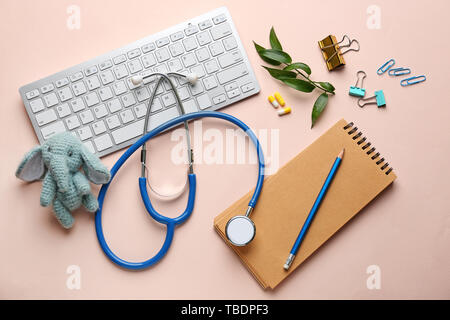 PC keyboard, stethoscope, stationery and toy on color background Stock Photo