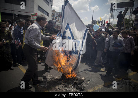 May 31, 2019 - Tehran, Tehran, Iran - Iranians burn Israel flag, during an anti-Israel rally marking Al Quds Day (Jerusalem Day), in support of Palestinian resistance against Israeli in Tehran, Iran. Each year Iran marks the last Friday of the fasting month of Ramadan as a solidarity day with the Palestinians. (Credit Image: © Rouzbeh Fouladi/ZUMA Wire) Stock Photo