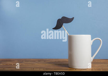 Father's day coffee mug with a paper mustache against a blue background Stock Photo