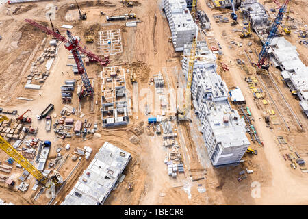 aerial top view of construction site. tower cranes and other building machinery working at the building of new city apartments Stock Photo