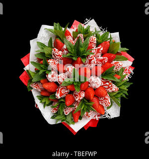 Ripe tasty strawberries decorated with white chocolate with fresh mint leaves isolated on black background Stock Photo