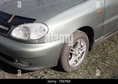 A fragment of the front of the modern car in the Parking lot near the Park. Stock Photo