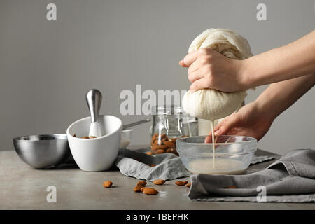 Woman making healthy almond milk in kitchen Stock Photo