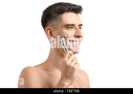 Man with facial massage tool on white background Stock Photo
