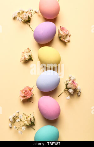 Easter eggs with flowers on color background Stock Photo