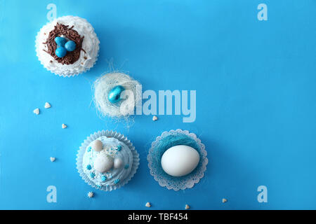 Tasty Easter cupcakes with eggs on color background Stock Photo