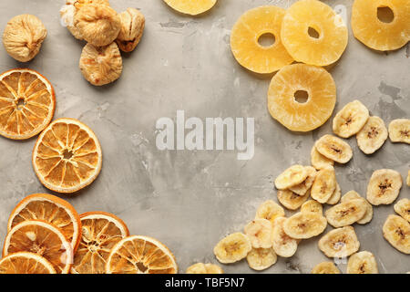 Frame made of assorted dried fruits on grey background Stock Photo