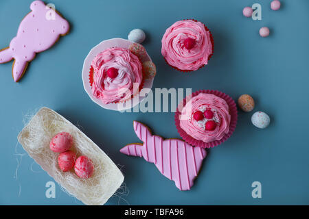Tasty Easter cupcakes with cookies on grey background Stock Photo