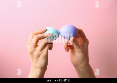 People knocking Easter eggs on color background Stock Photo