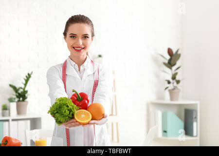 Portrait of female nutritionist with healthy products in her office Stock Photo