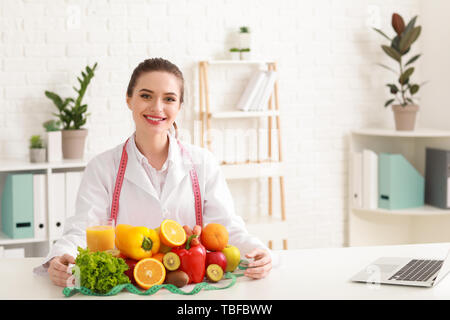 Portrait of female nutritionist with healthy products in her office Stock Photo