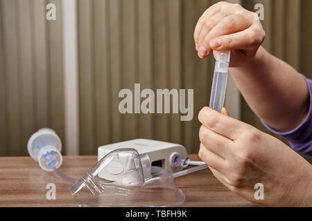 Making medicine for nebulizer chamber with compressor nebuliser system near on the table, nebulizer helps people with asthma. Stock Photo