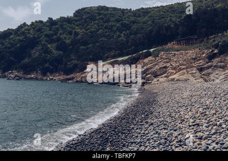 bay in Taejongdae park with pebble beach and forest on the hill Stock Photo