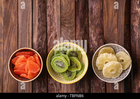 Bowls with tasty dried fruits on wooden background Stock Photo