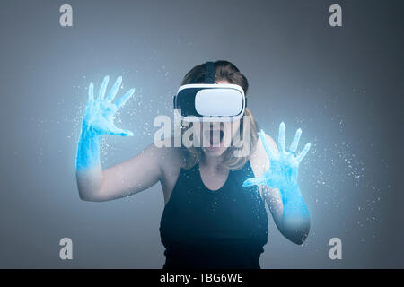 Girl using VR gadget with hands turning into ice in a virtual cyber simulator Stock Photo