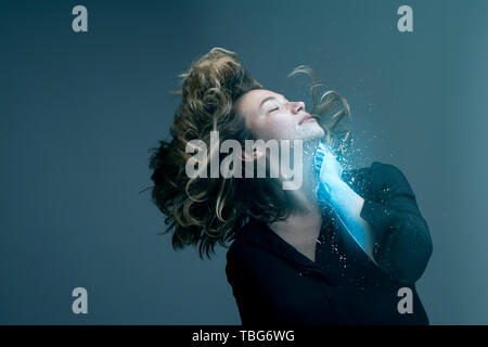 Woman with flying hair and hand transforming into ice in a virtual reality Stock Photo