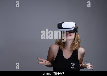 Female using VR gear is having fun and displaying a don't know attitude Stock Photo
