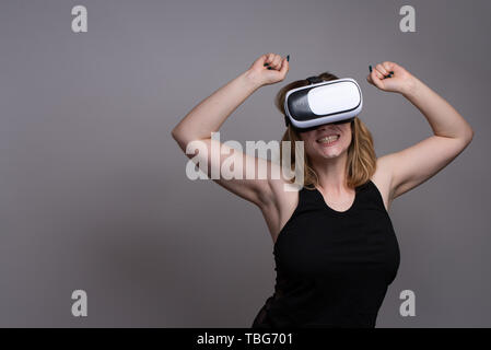 Happy girl using a VR gadget during a cyber reality simulation Stock Photo