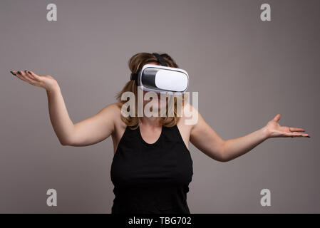 Female using VR gear is displaying a don't know attitude Stock Photo