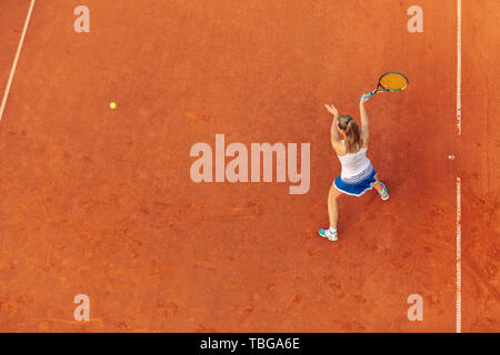 Aerial shot of a female tennis player on a court during match. Young woman playing tennis.High angle view. Stock Photo