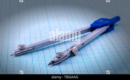 metal compasses over blue graph paper Stock Photo
