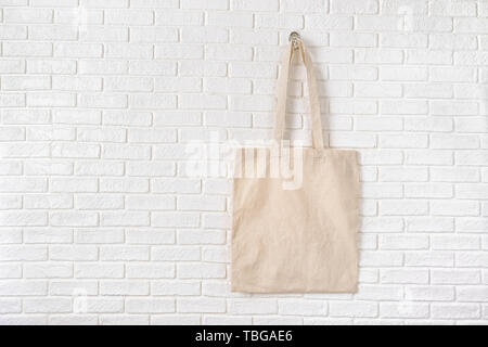 Mock up Tote bag eco hipster white cotton fabric Shopping bag in blue .  white brick eall rustic background Stock Photo - Alamy