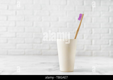 Bamboo toothbrush in holder on white background. Stock Photo