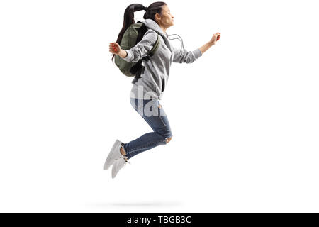 Full length profile shot of a young female student jumping isolated on white background Stock Photo