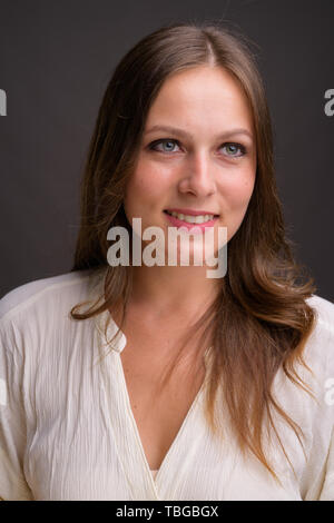 Studio shot of young beautiful businesswoman against gray background Stock Photo