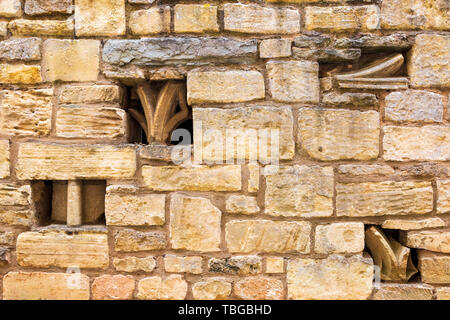 Church stone ornament fragments embedded in a Cotswold stone wall Stock Photo