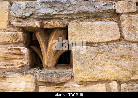 Church stone ornament fragments embedded in a Cotswold stone wall Stock Photo