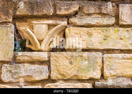 Church stone ornament fragments embedded in a Cotswold stone wall Stock Photo