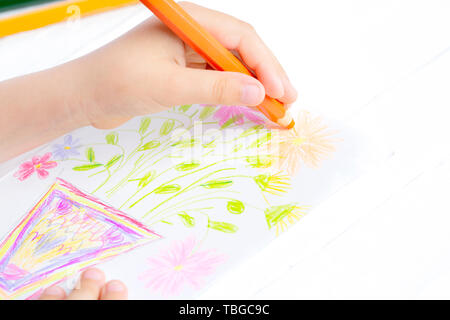 The child draws flowers for mom with pencils. Baby gift. Stock Photo