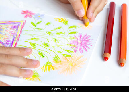 The child draws flowers for mom with pencils. Baby gift. Stock Photo