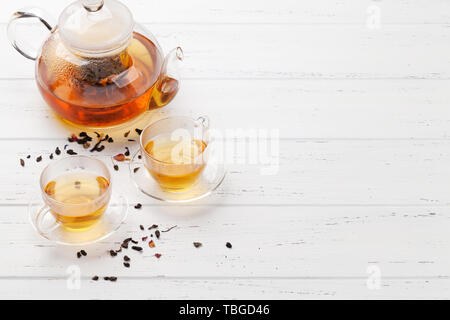 Herbal and fruit tea, teapot and cups on wooden table. With copy space Stock Photo