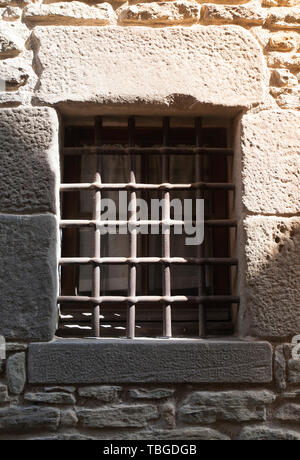window with iron grating on stone wall Stock Photo
