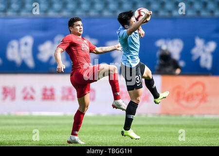 Brazilian football player Elkeson de Oliveira Cardoso, or simply Elkeson, left, of Shanghai SIPG challenges a player of Dalian Yifang in their 12th round match during the 2019 Chinese Football Association Super League (CSL) in Dalian city, northeast China's Liaoning province, 2 June 2019. Stock Photo